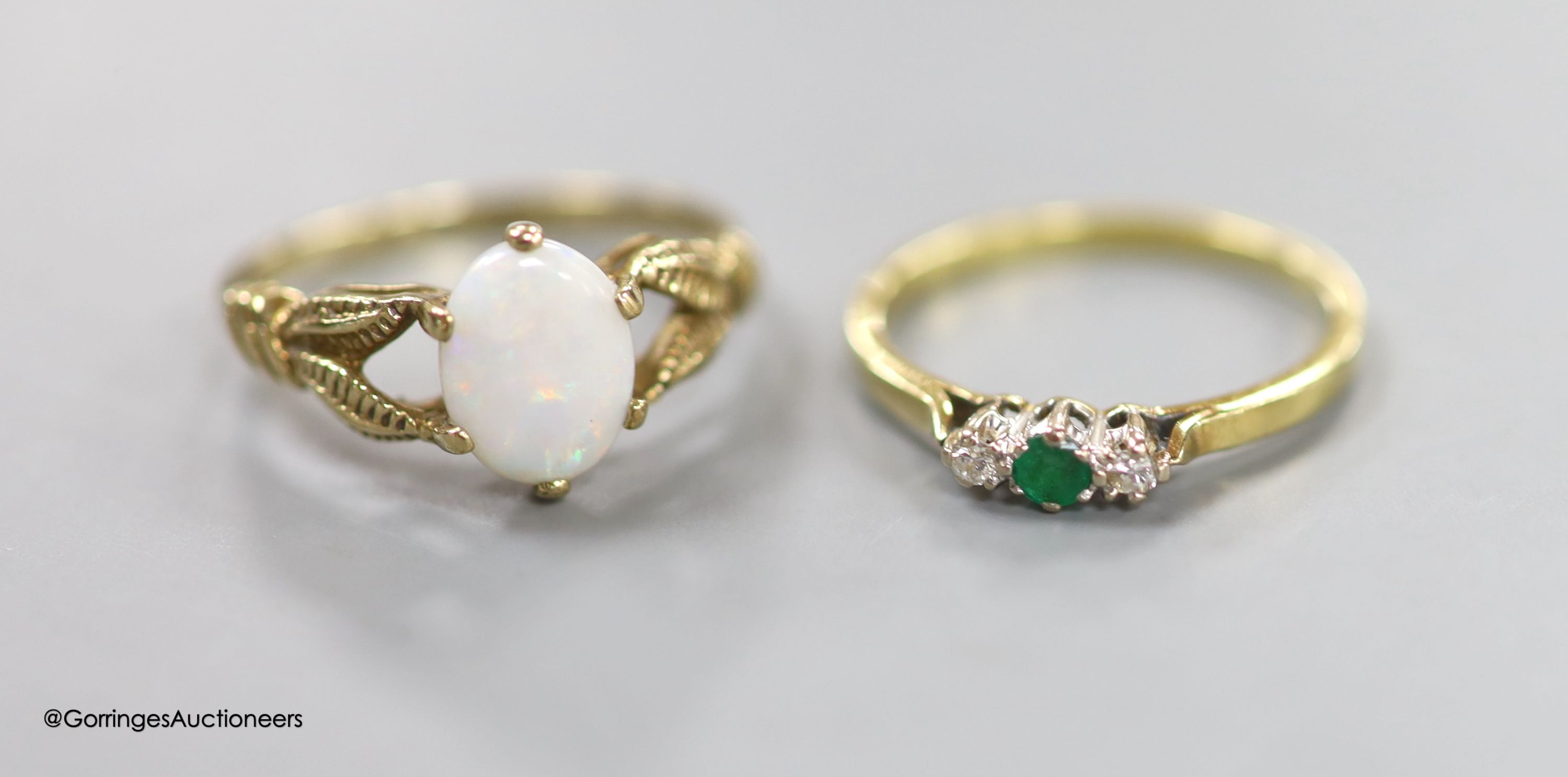 An 18ct gold, emerald and diamond three-stone ring, size M, gross 1.9 grams, a 9ct gold and opal ring and a 9ct gold 'heart' bracelet, gross 5.9 grams.